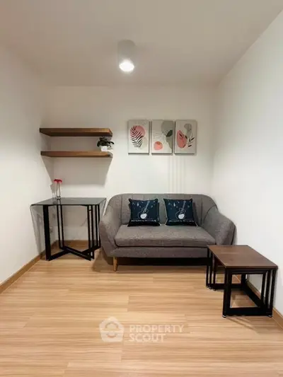 Cozy living room with modern decor and wooden flooring, featuring a stylish sofa and wall art.