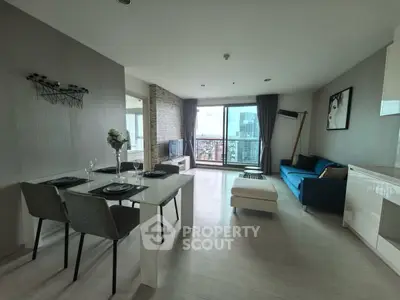 Modern open-plan living room with city view, stylish decor, and dining area.