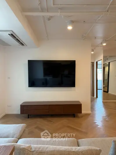 Modern living room with sleek TV setup and stylish wooden flooring