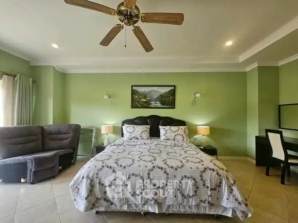 Spacious bedroom with elegant decor and ceiling fan, perfect for relaxation.