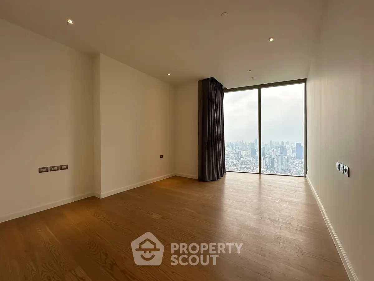 Spacious empty room with stunning city view and floor-to-ceiling windows.