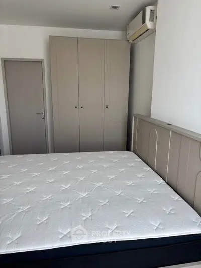 Modern bedroom with sleek wardrobe and air conditioning unit, perfect for comfort and style.