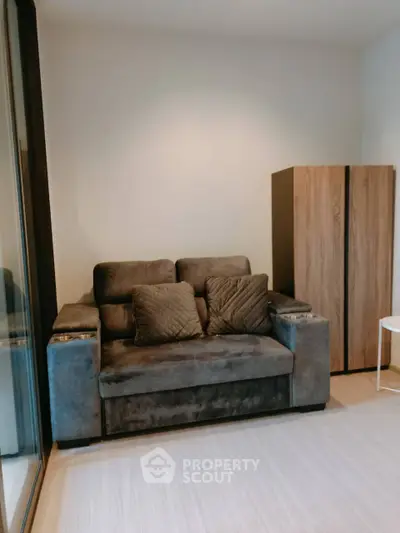 Cozy living room with plush sofa and modern wooden cabinet, perfect for relaxation.