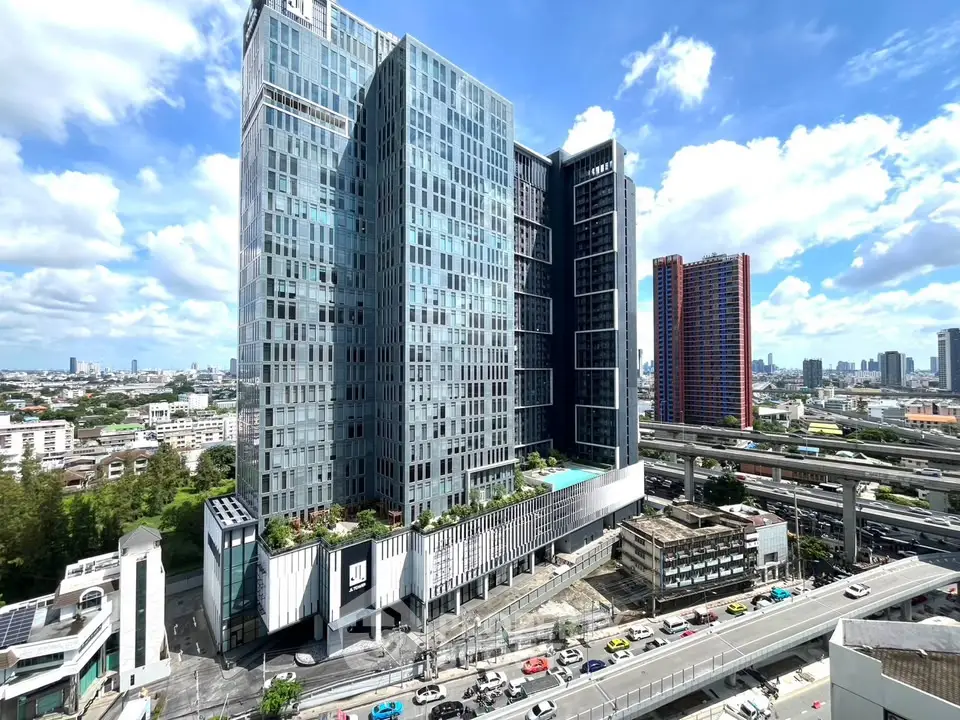 Stunning modern high-rise building with panoramic city views and rooftop pool, perfect for urban living.