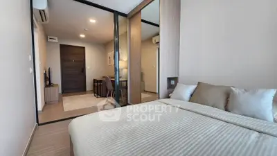 Modern bedroom with elegant decor and sliding glass doors leading to a cozy living area.