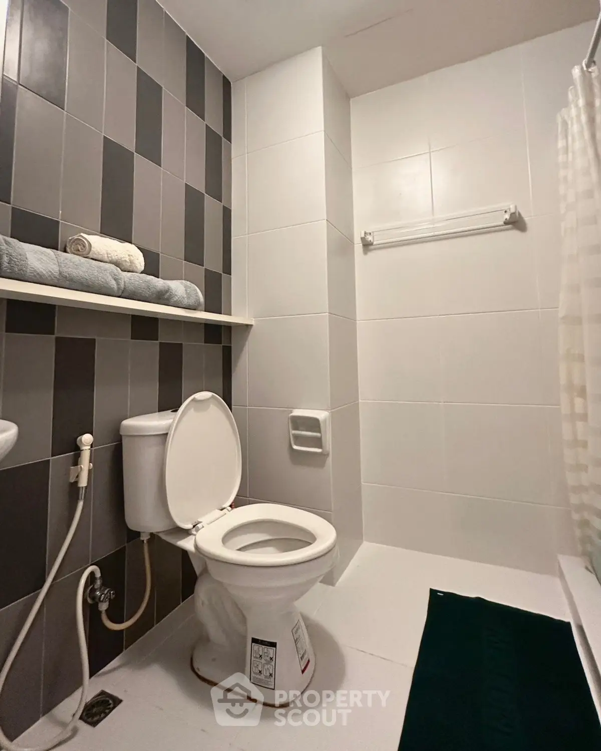 Modern bathroom with sleek tiles and essential fixtures in a contemporary apartment.