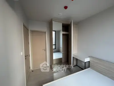 Modern bedroom with sleek wooden furniture and mirrored wardrobe in a minimalist design.