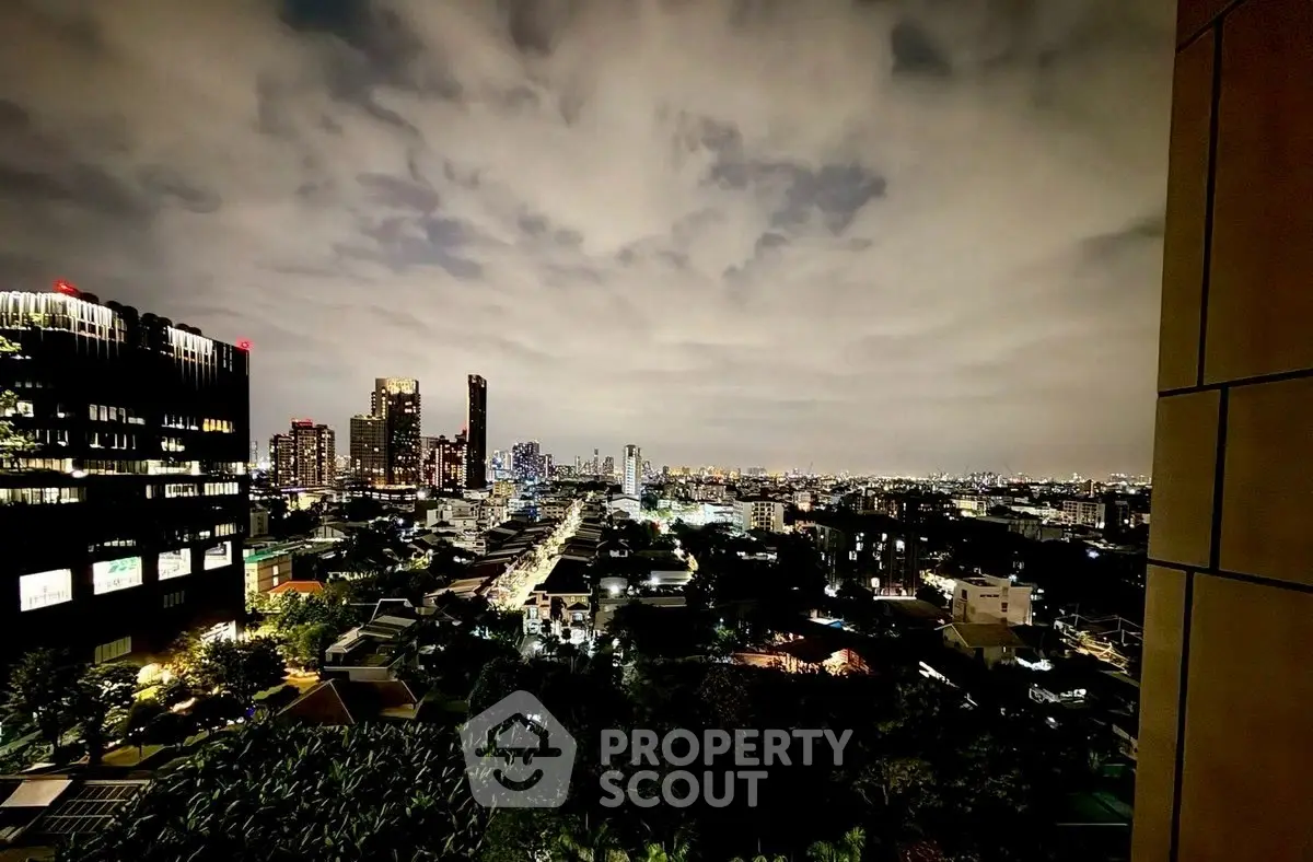 Stunning cityscape view from a high-rise building at night, showcasing vibrant urban lights.