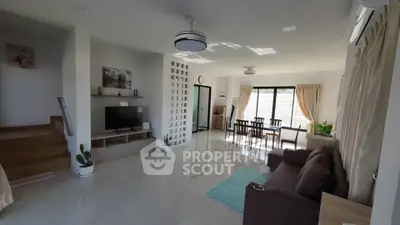 Spacious modern living room with dining area, natural light, and stylish decor