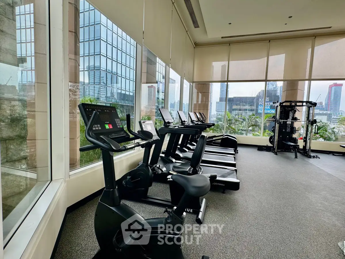 Modern gym with city view, featuring state-of-the-art exercise equipment and large windows.
