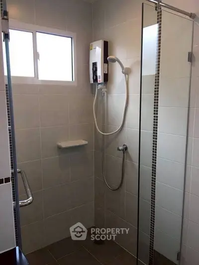 Modern bathroom with glass shower and electric water heater
