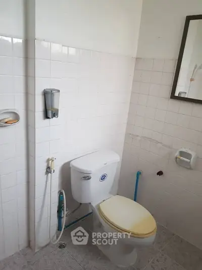 Simple bathroom with white tiles and basic fixtures, ideal for budget-friendly living spaces.