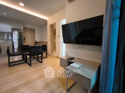 Modern living room with open kitchen and sleek furniture in contemporary apartment.
