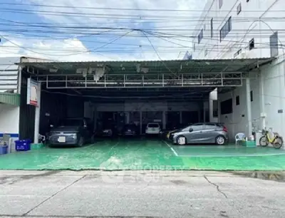 Spacious covered parking area with multiple cars in a commercial building.