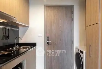 Modern compact kitchen with wooden cabinetry and washing machine
