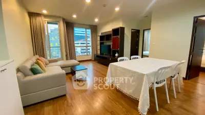 Spacious living room with modern decor and dining area in a stylish apartment.