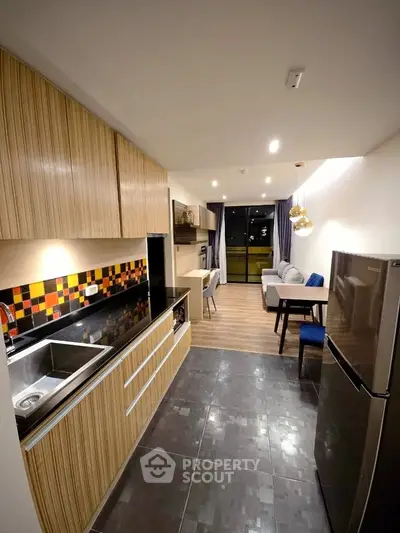 Modern open-layout kitchen and living room with stylish decor and vibrant backsplash.