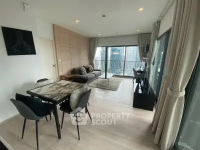 Modern living room with city view, featuring stylish furniture and large windows for natural light.