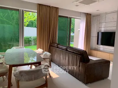Luxurious living room with garden view, featuring modern furniture and elegant decor.