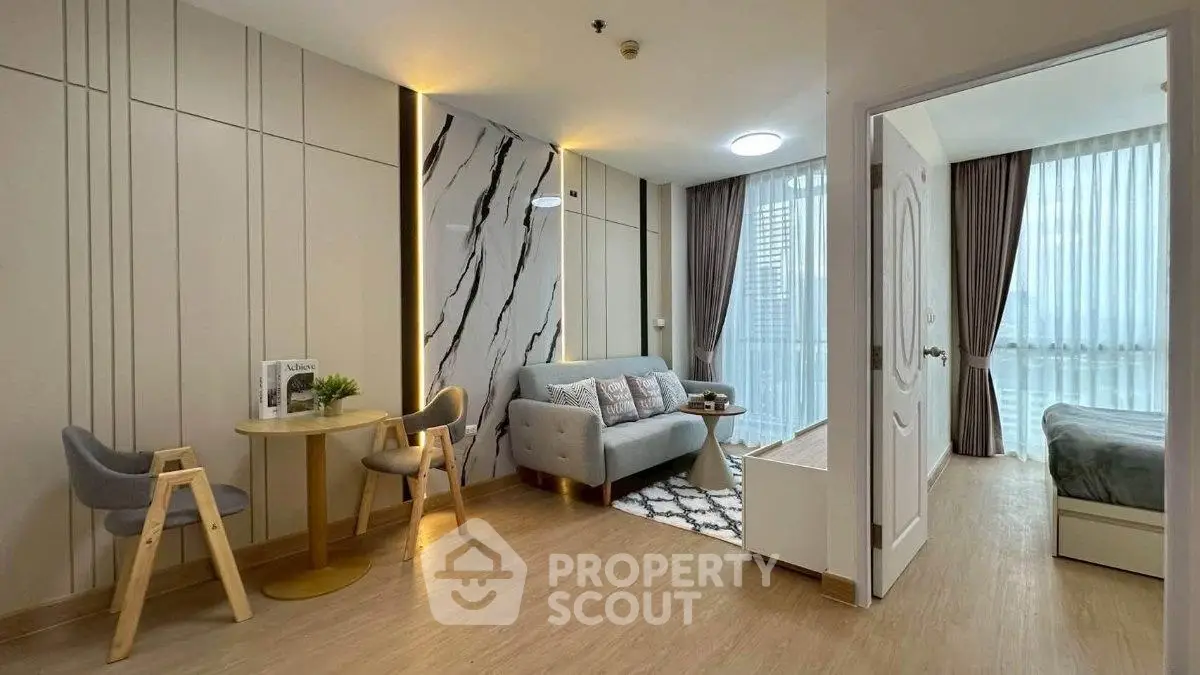 Modern living room with stylish decor and adjacent bedroom in a contemporary apartment.