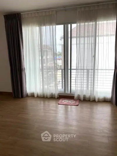 Spacious room with large windows and wooden flooring, perfect for natural light lovers.