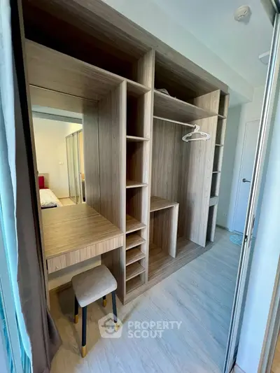 Spacious walk-in closet with wooden shelves and vanity in modern apartment