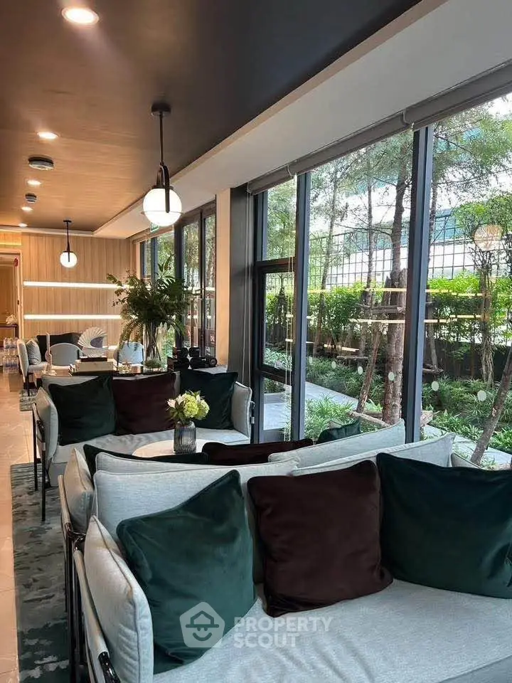 Luxurious modern living room with large windows and garden view, featuring elegant decor and plush seating.