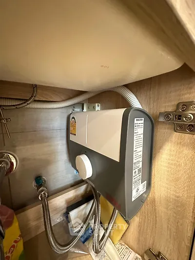 Compact under-sink water heater installation in modern kitchen cabinet