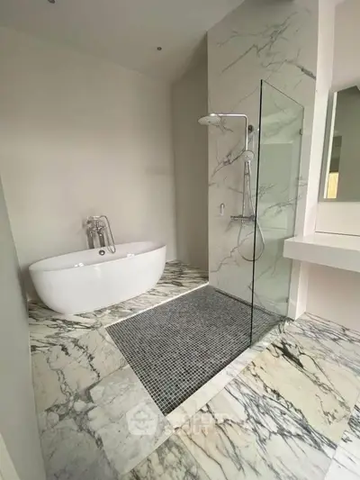 Luxurious marble bathroom with freestanding tub and glass shower