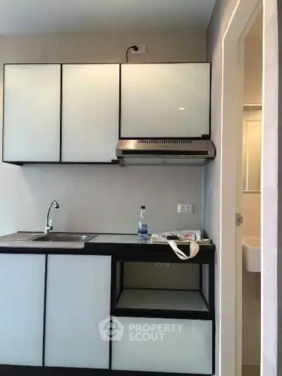 Modern compact kitchen with sleek cabinets and stainless steel range hood