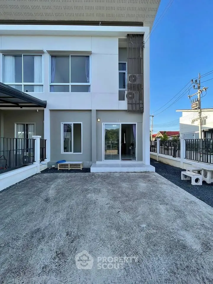 Modern townhouse exterior with spacious driveway and large windows