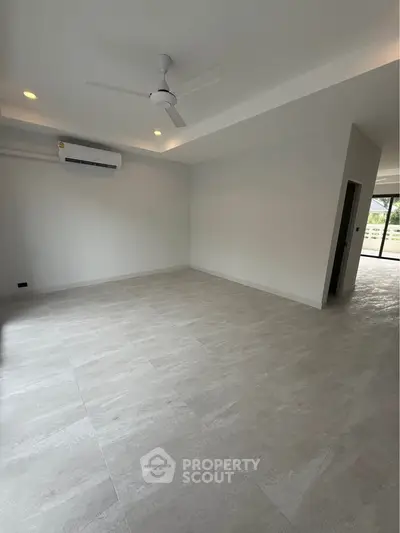 Spacious modern living room with ceiling fan and air conditioning