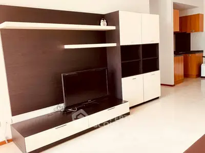 Modern living room with sleek TV unit and open kitchen layout