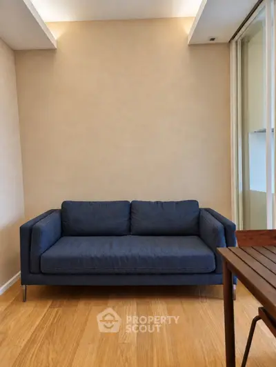 Modern living room with stylish blue sofa and wooden flooring, perfect for cozy relaxation.