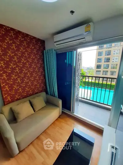 Modern living room with balcony overlooking pool in urban apartment