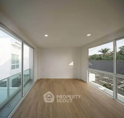 Spacious corner unit with floor-to-ceiling windows and wooden flooring, offering abundant natural light.