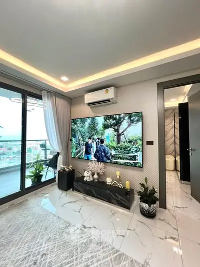 Modern living room with large TV, marble flooring, and balcony view.