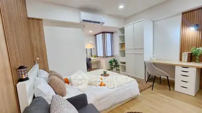 Modern bedroom with cozy decor and study area, featuring wooden accents and ample natural light.