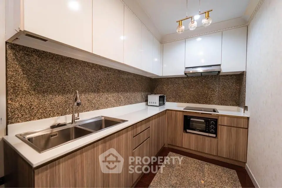 Modern kitchen with sleek cabinetry and built-in appliances in a stylish corner layout.