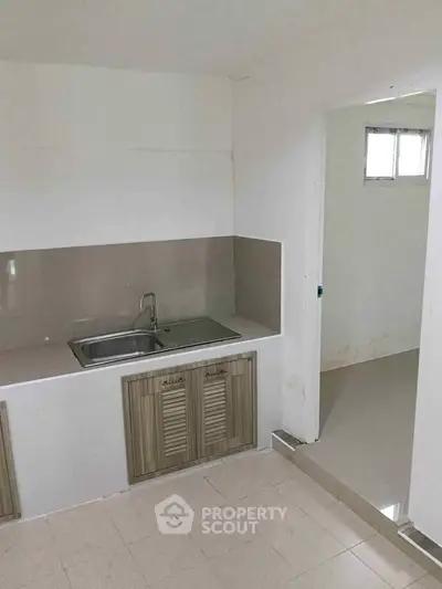 Minimalist kitchen with sleek cabinetry and modern sink in a compact space.