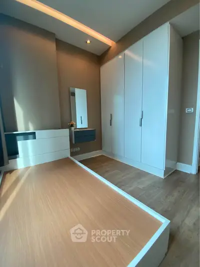 Modern bedroom with sleek built-in wardrobe and wooden flooring