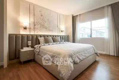 Luxurious bedroom with elegant decor and large window offering natural light