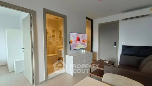 Modern living room with sleek furniture and adjacent bathroom view