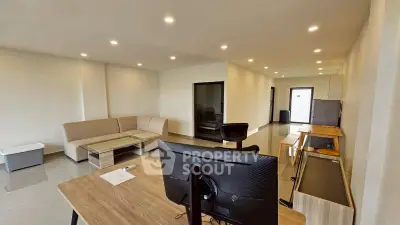 Spacious modern living room with sleek furniture and ample lighting, perfect for relaxation and entertainment.