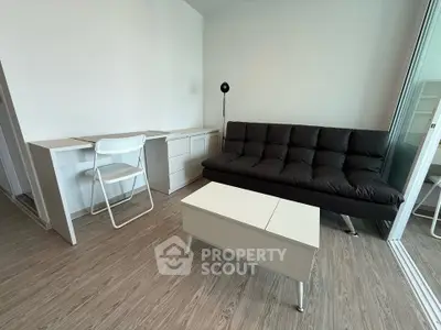 Modern living room with sleek black sofa and minimalist white furniture
