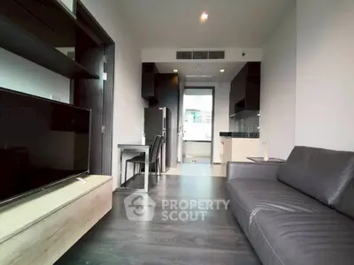 Modern living room with sleek furniture and open kitchen layout in a stylish apartment.