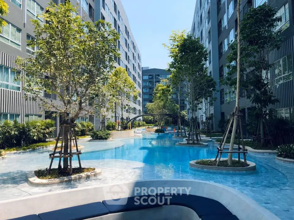 Luxurious apartment complex with stunning pool and lush greenery