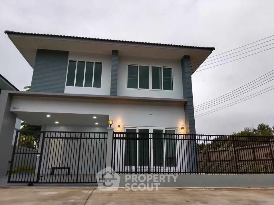 Modern two-story house with sleek design and gated entrance, perfect for family living.