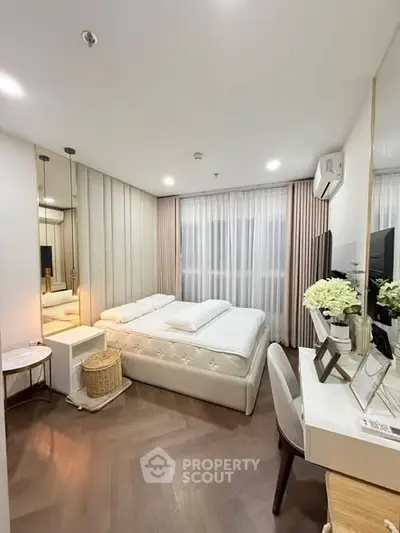 Modern bedroom with elegant decor and natural light, featuring a cozy bed and stylish furniture.