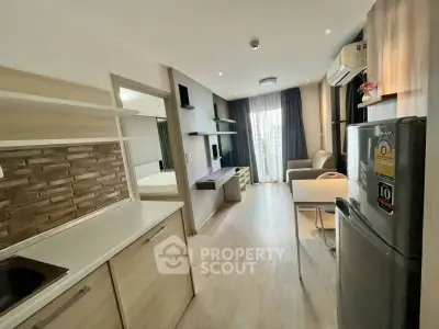 Modern open-layout apartment with stylish kitchen and cozy living area, featuring natural light and contemporary design.